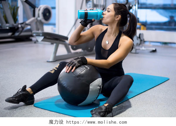 户外锻炼工作结束后的健身运动员女人在喝水